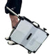 Hand holding a transportable ball machine with wheels on a white background